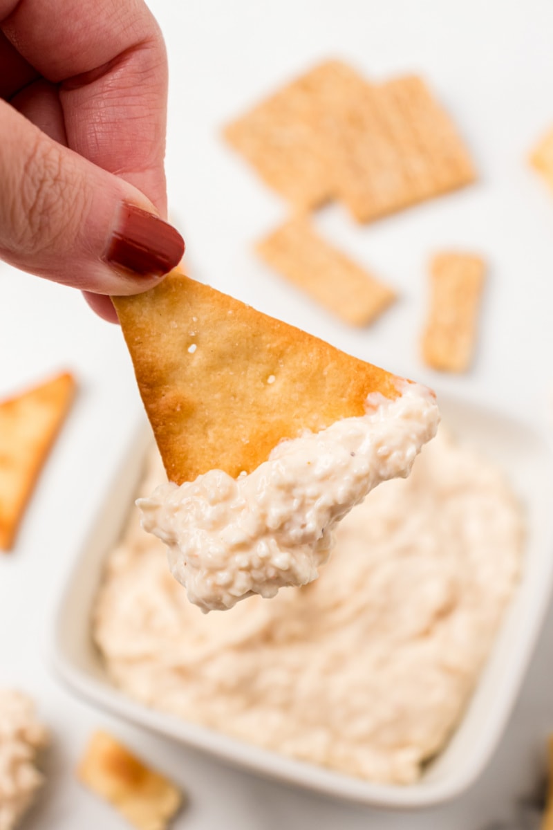 cracker dipped into sweet caramelized onion spread