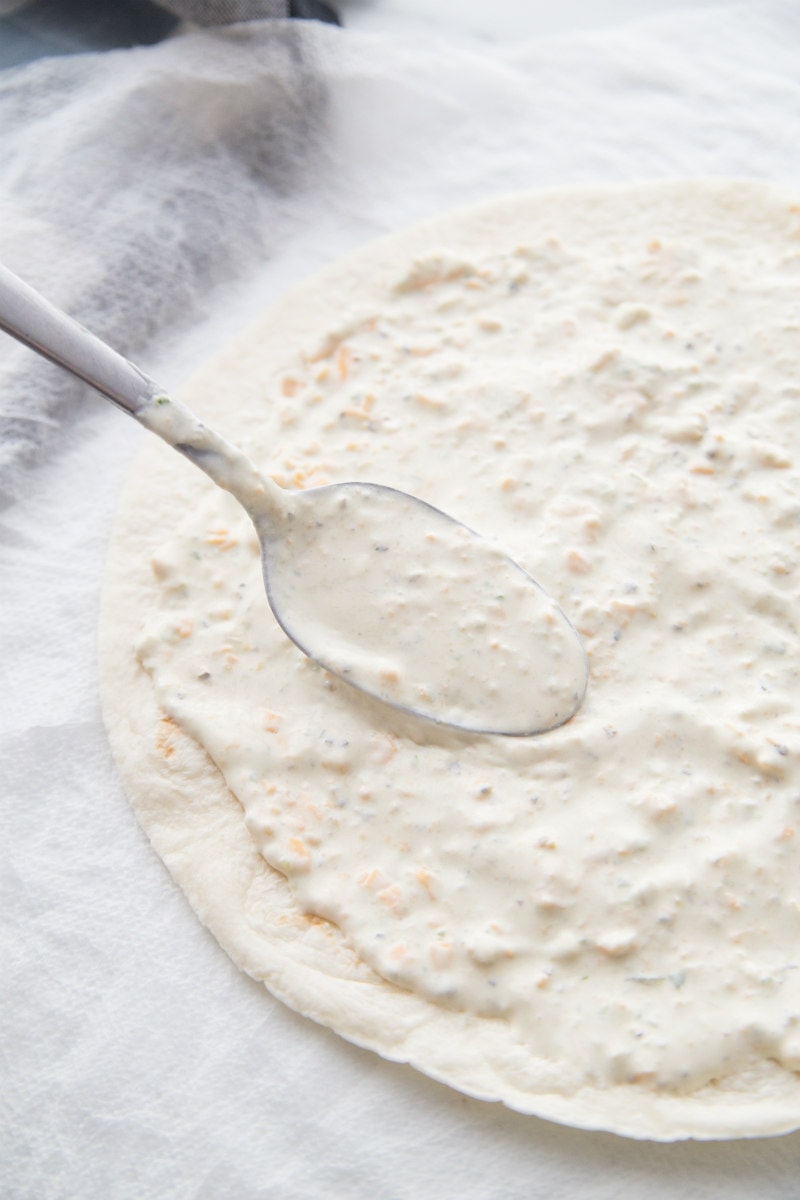 spreading sauce onto Texas Tortilla Roll Ups