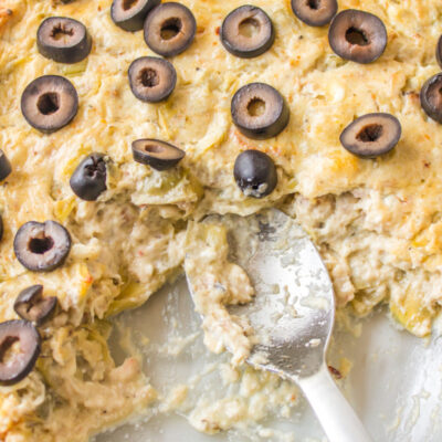 warm crab dip in a baking dish with a spoon