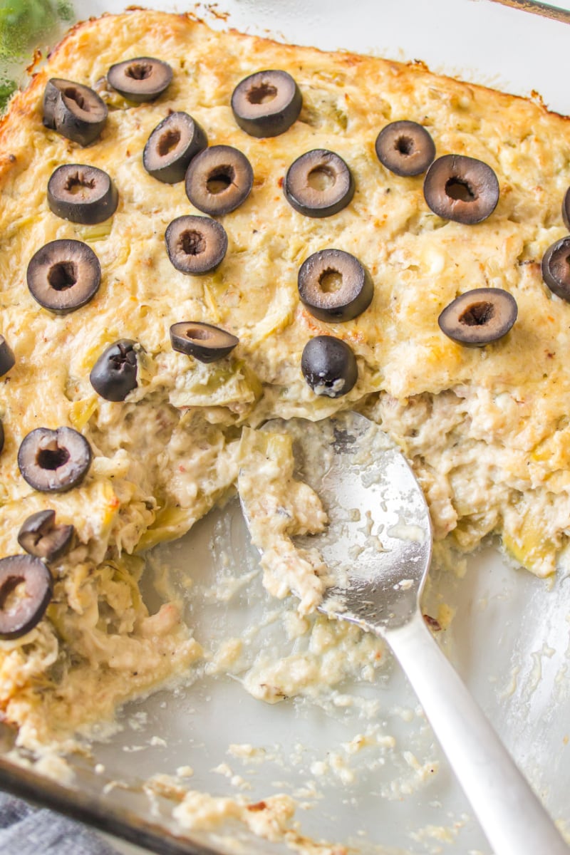 warm crab dip in a baking dish with a spoon