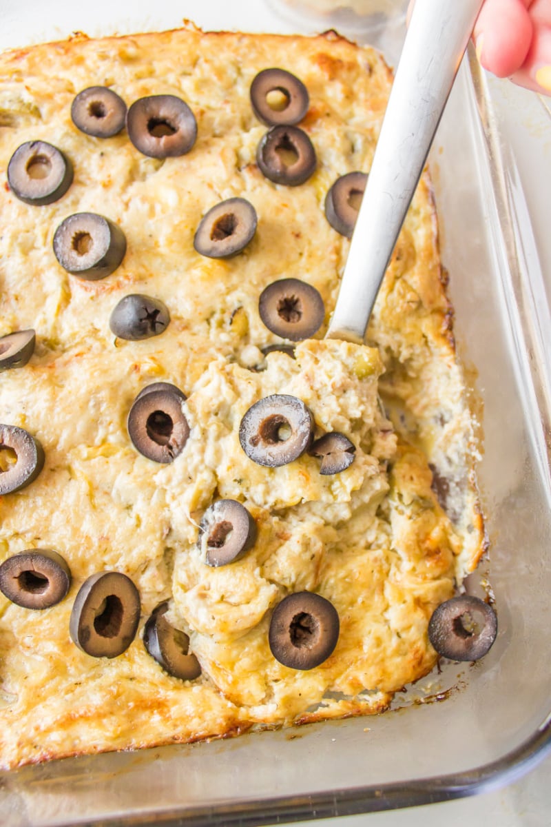 warm crab dip in a baking dish with a spoon