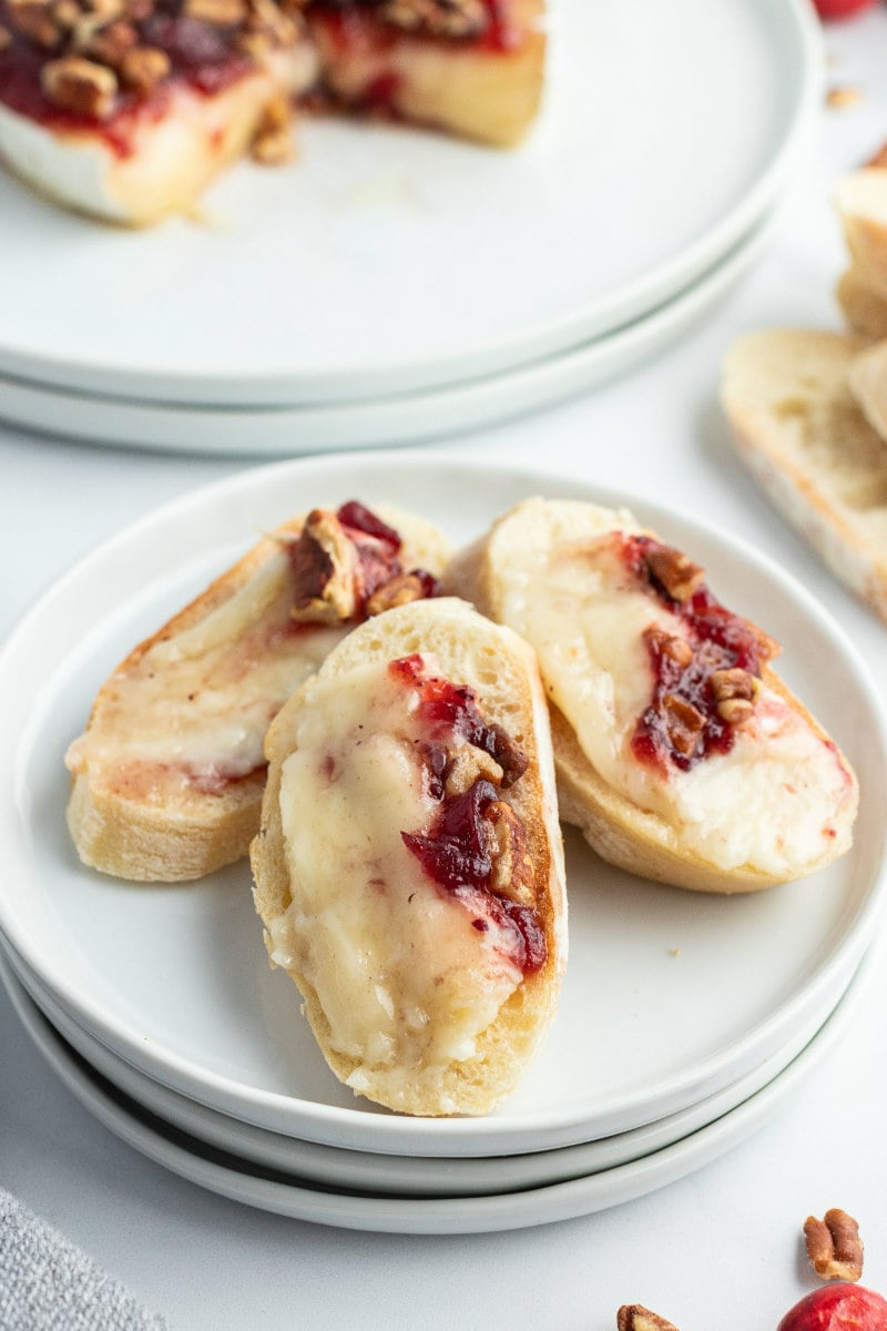 white plate stack with three cranberry brie on baguette