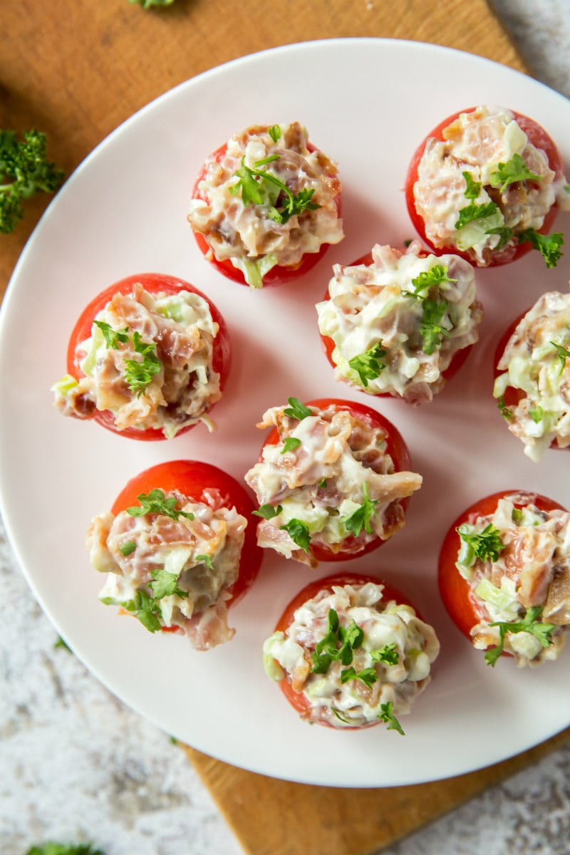 overhead shot of a white plate with bacon stuffed cherry tomatoes on top