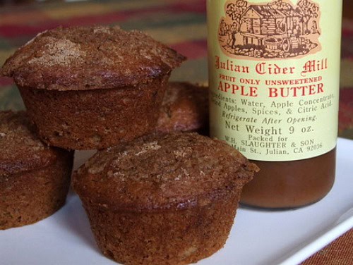 apple butter muffins next to a jar of apple butter