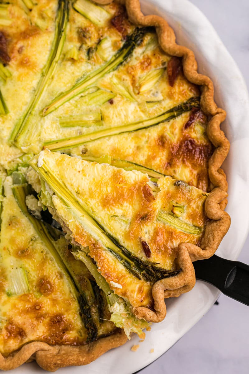 spatula taking out slice of asparagus quiche
