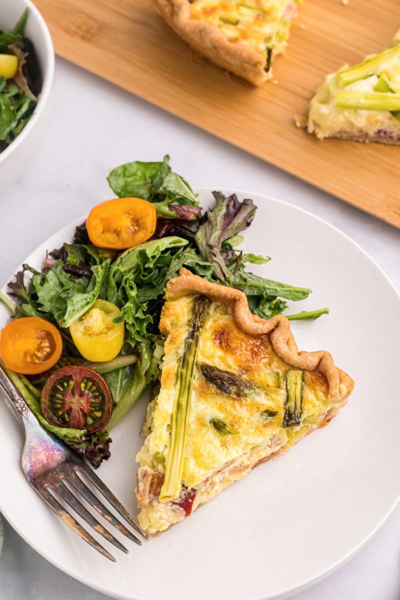 slice of quiche on a plate with salad