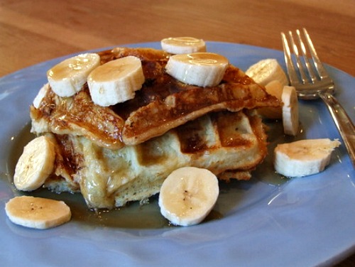 Banana Waffles on a blue plate topped with banana slices