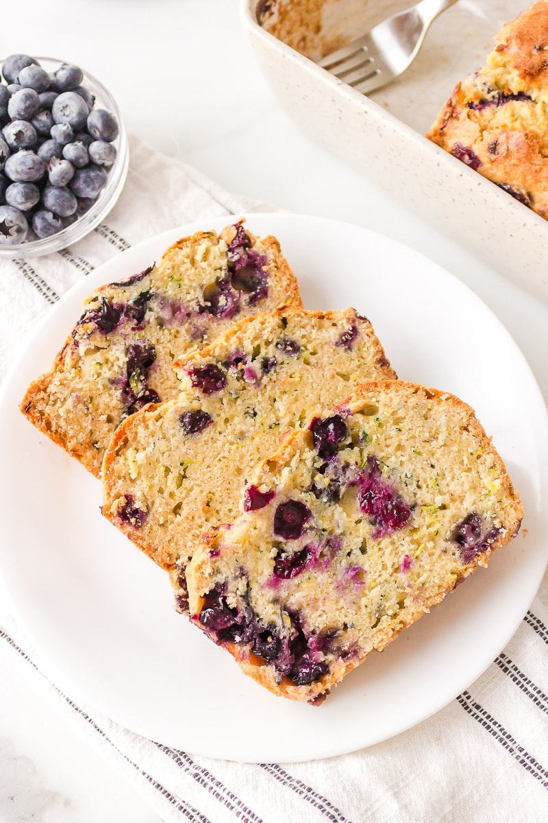 three sliced blueberry zucchini bread on plate