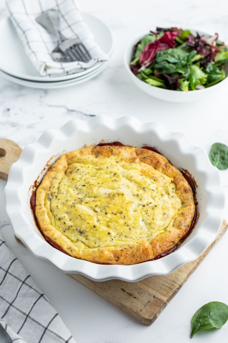 brie and canadian bacon quiche in white pan just out of oven