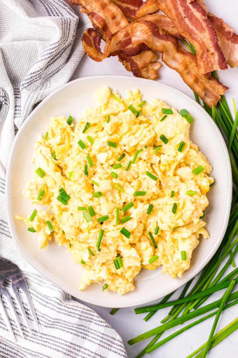 scrambled eggs on a plate with chives on top