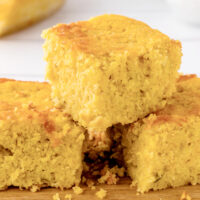 green chile cornbread pieces stacked on board