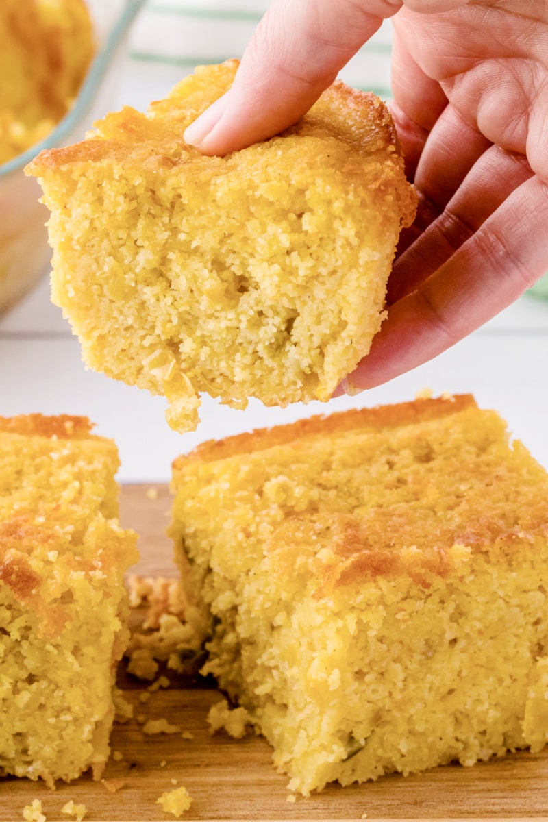 hand picking up piece of cornbread