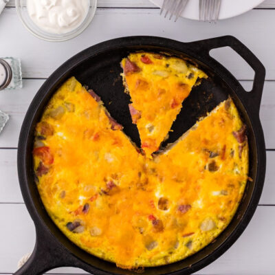 o'brien frittata in cast iron skillet with slice cut