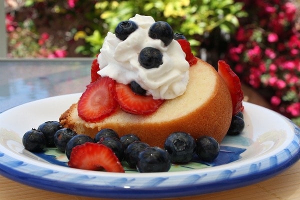 Cream Cheese Pound Cake topped with cream and berries