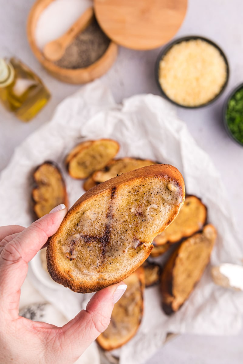 hand holding piece of garlic bread