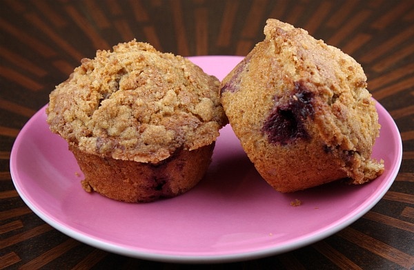 two raspberry muffins on a pink plate