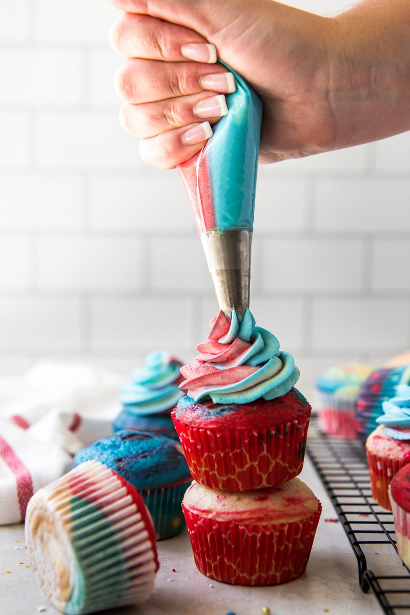 frosting red white and blue cupcakes with a piping bag