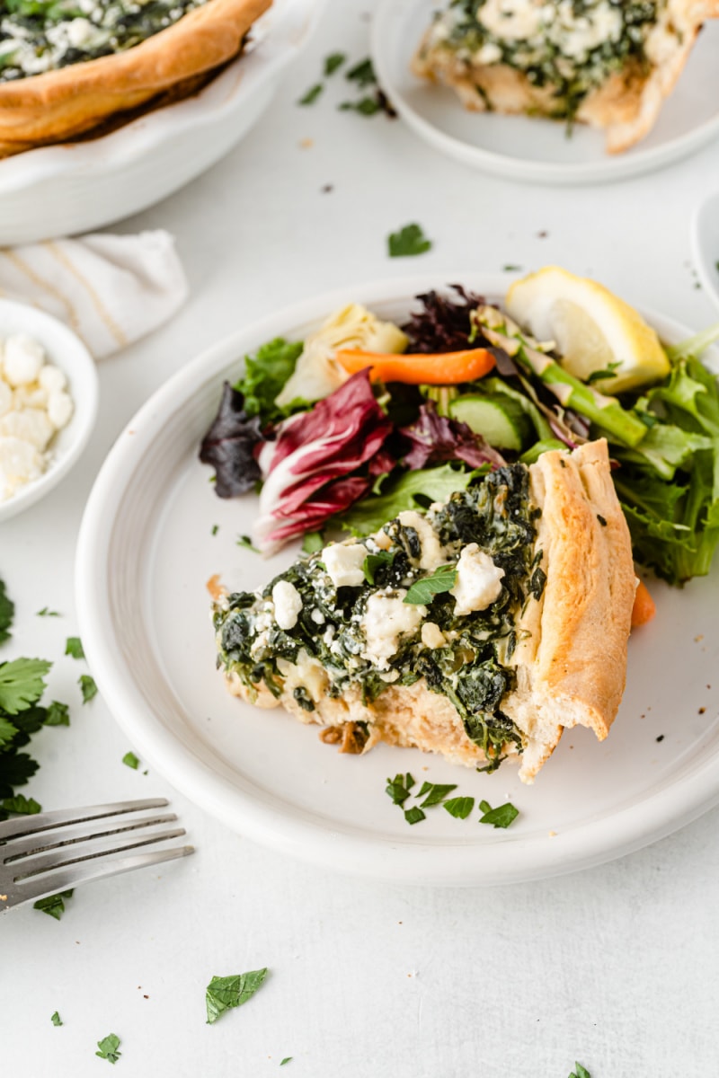 slice of quiche on plate with salad