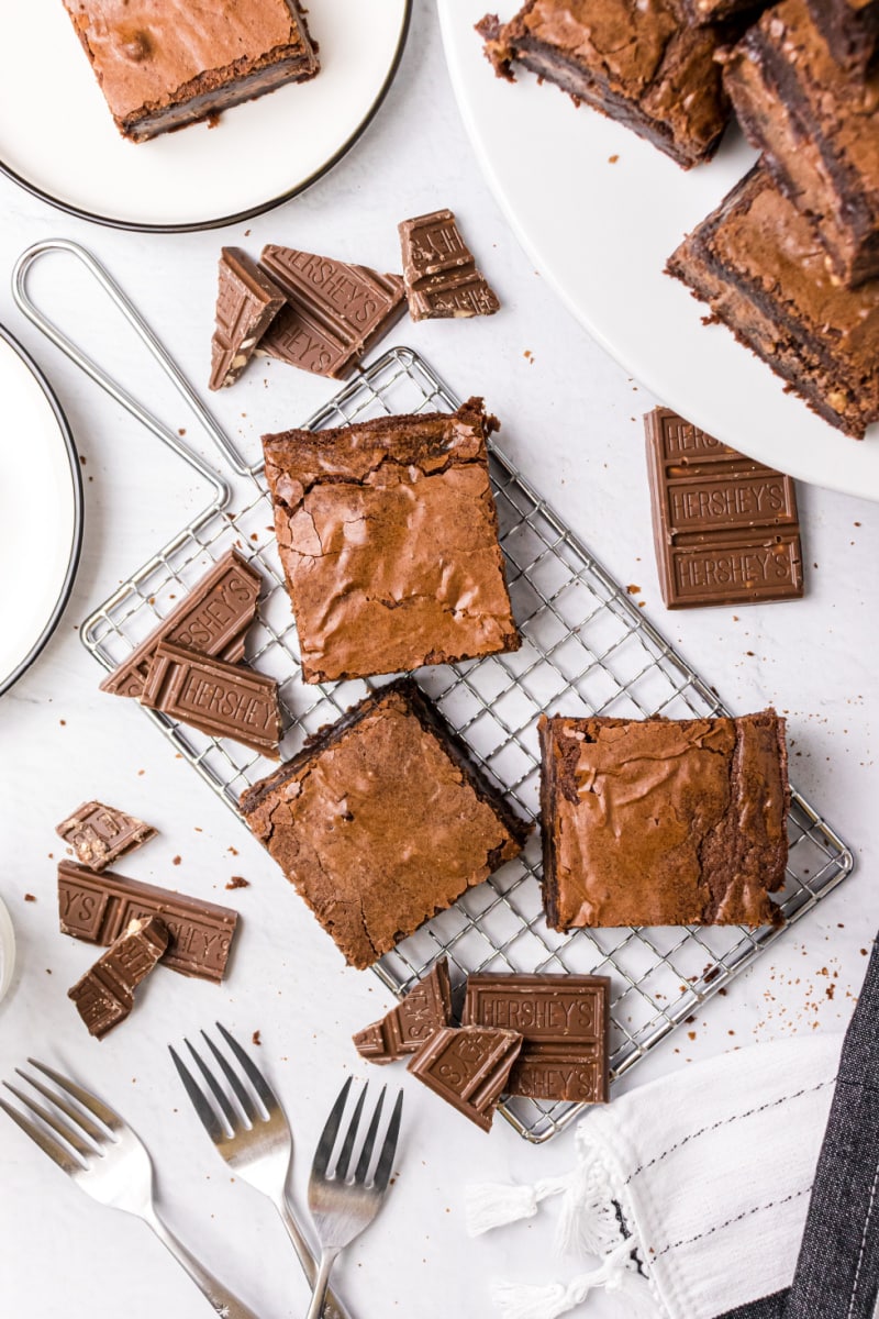 overhead shot of brownies on a baking rack with pieces of chocolate bar