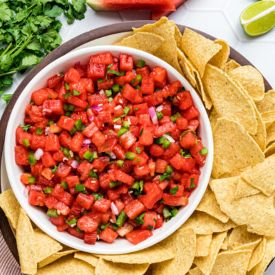 bowl of watermelon salsa with chips surrounding
