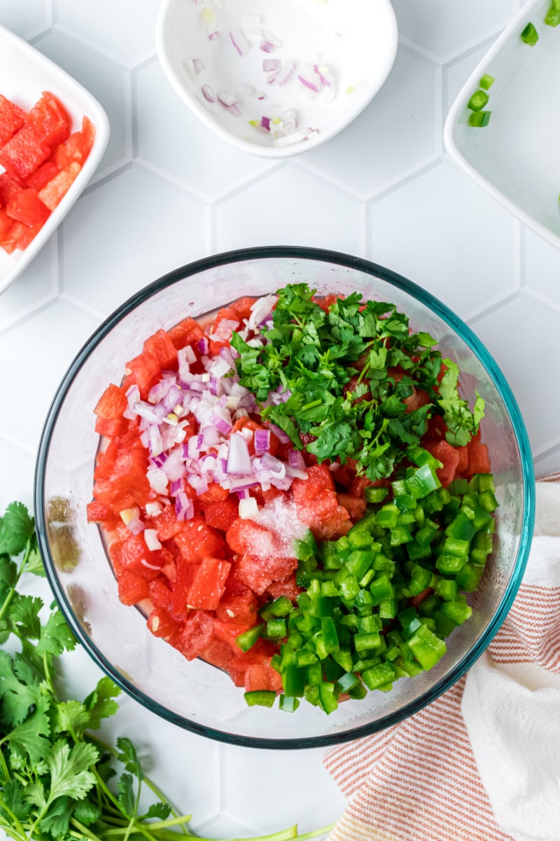 bowl of ingredients ready to be stirred to make watermelon salsa