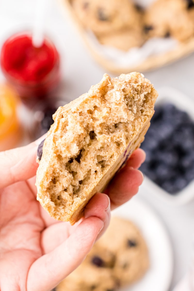 hand holding broken open blueberry biscuit