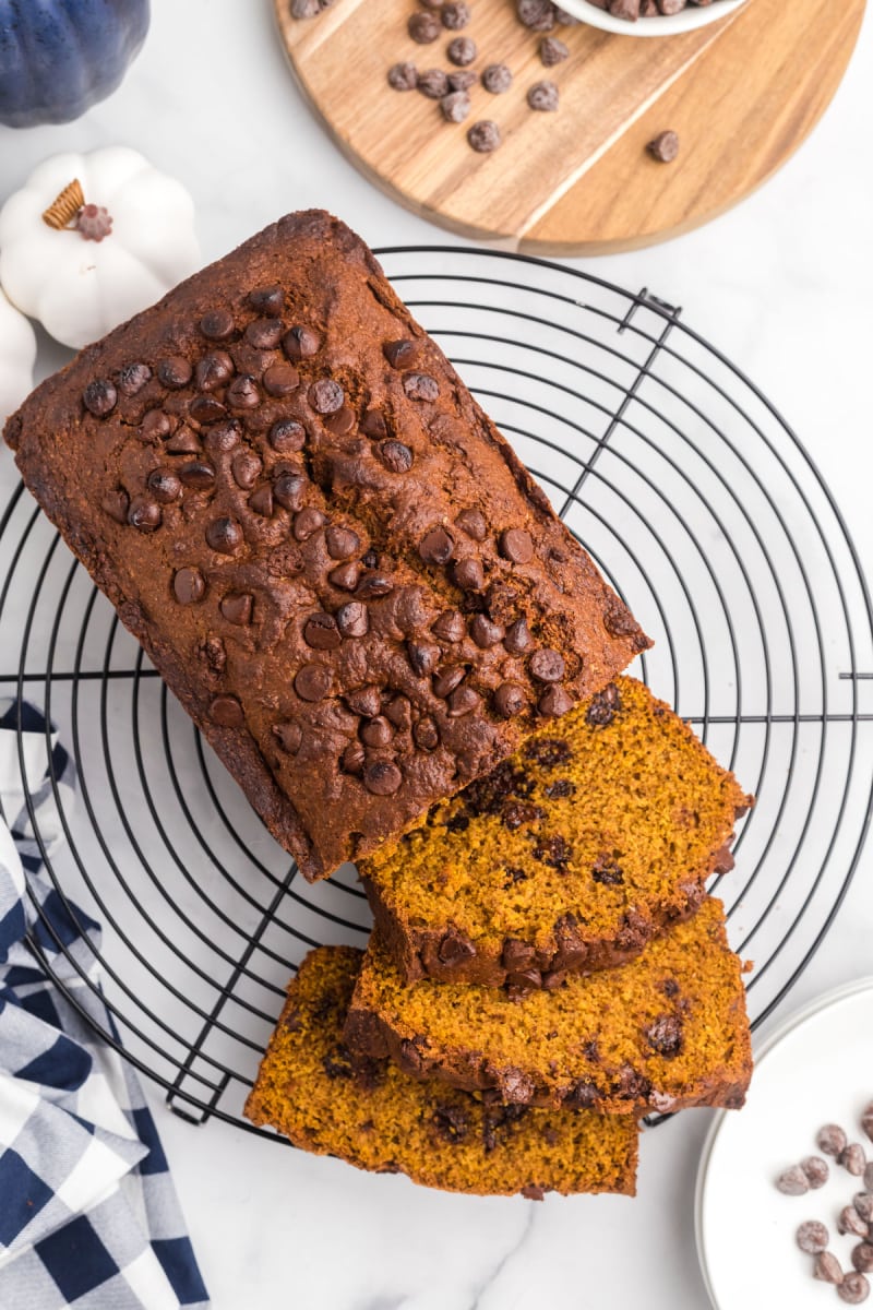 loaf of whole wheat chocolate chip pumpkin bread on a rack sliced open