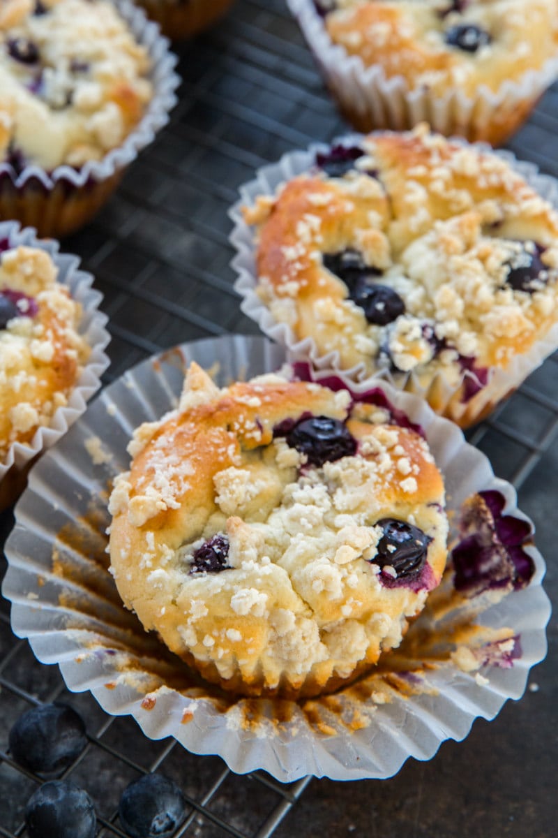 blueberry muffins displayed, and the one in front is unwrapped