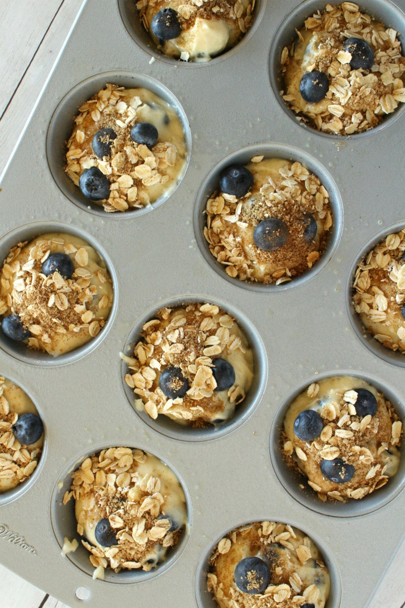 making blueberry cinnamon muffins batter in muffin pan