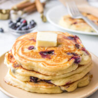 stack of blueberry pancakes with pat of butter on top