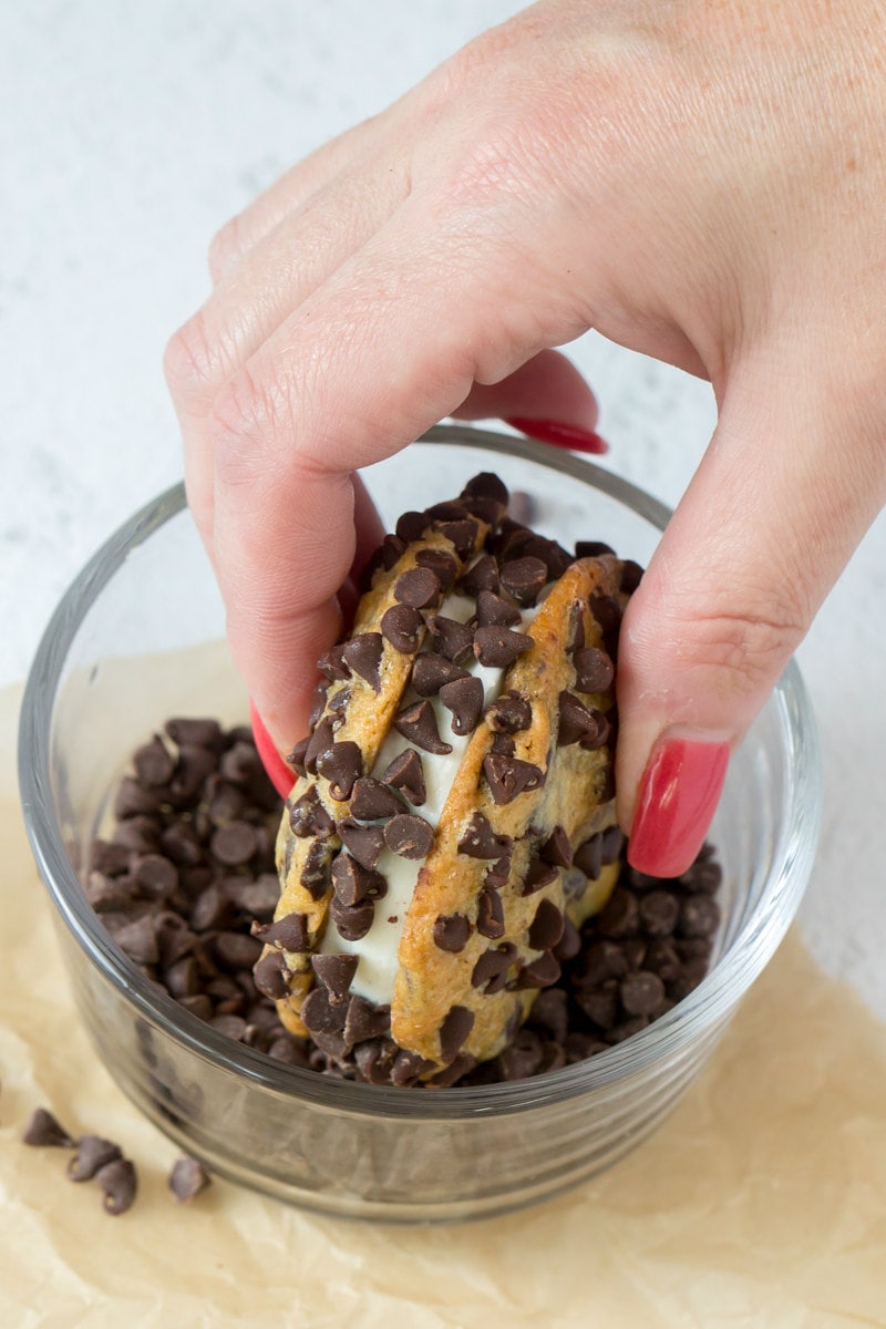 making chocolate chip ice cream sandwiches by dunking the ice cream sandwich