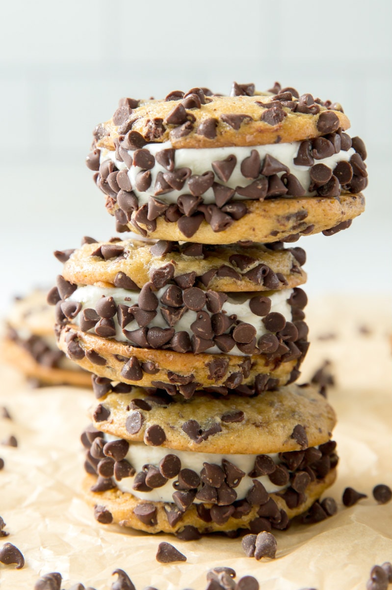 three stacked chocolate chip ice cream sandwiches with chocolate chips scattered around