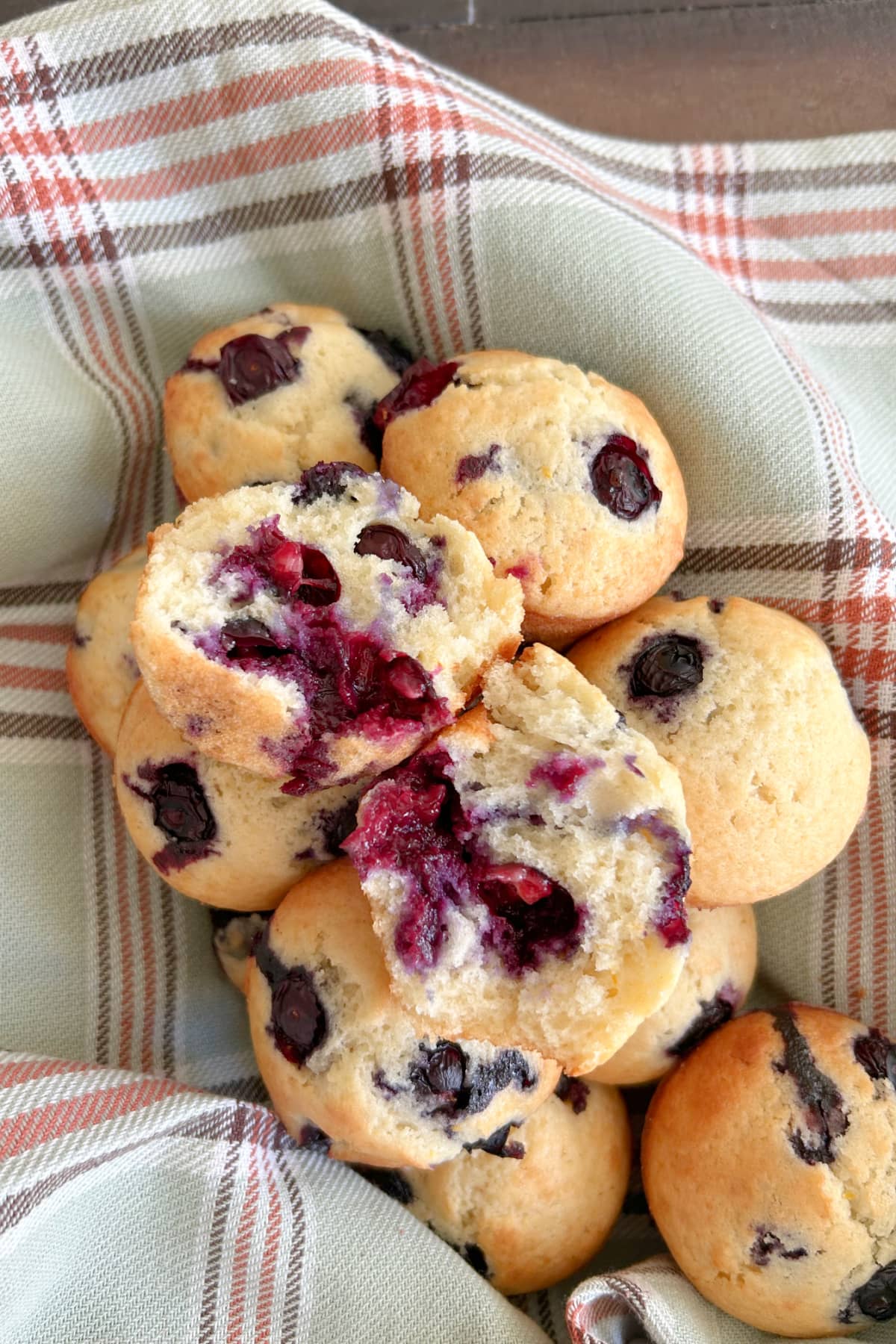 blueberry muffins in basket with one broken open