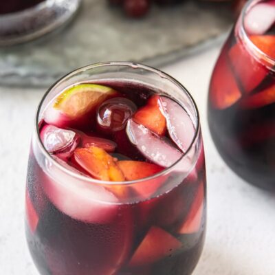 looking overhead into a glass of red wine sangria with peaches