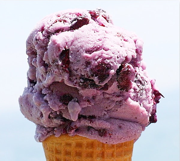 scoop of blueberry cheesecake ice cream on a sugar cone