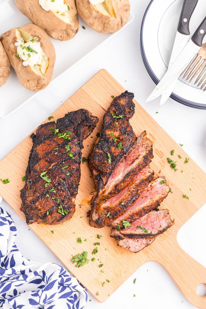 steak on a wood board with sliced steak too