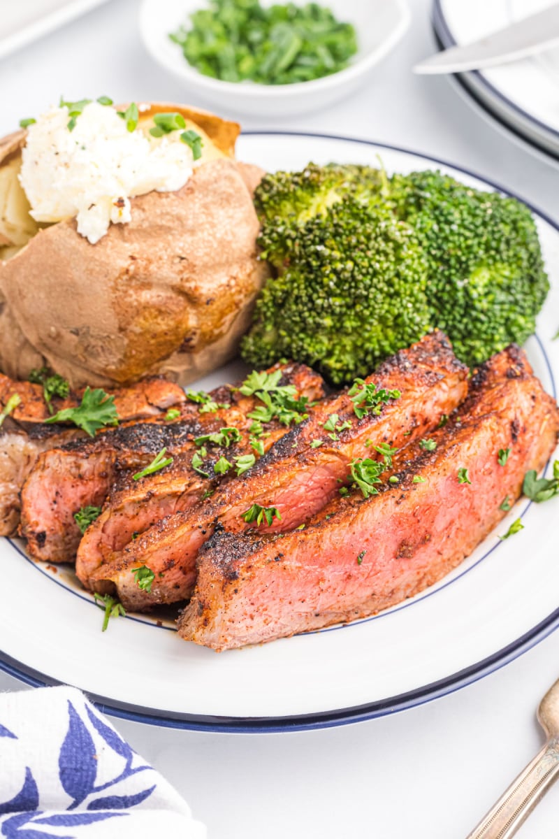 sliced steak on a plate with broccoli and potato