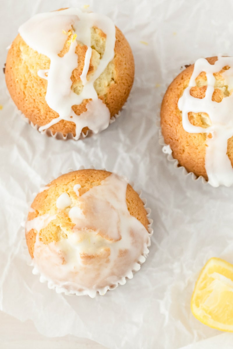 overhead shot of lemon pound cake muffins with glaze and a lemon