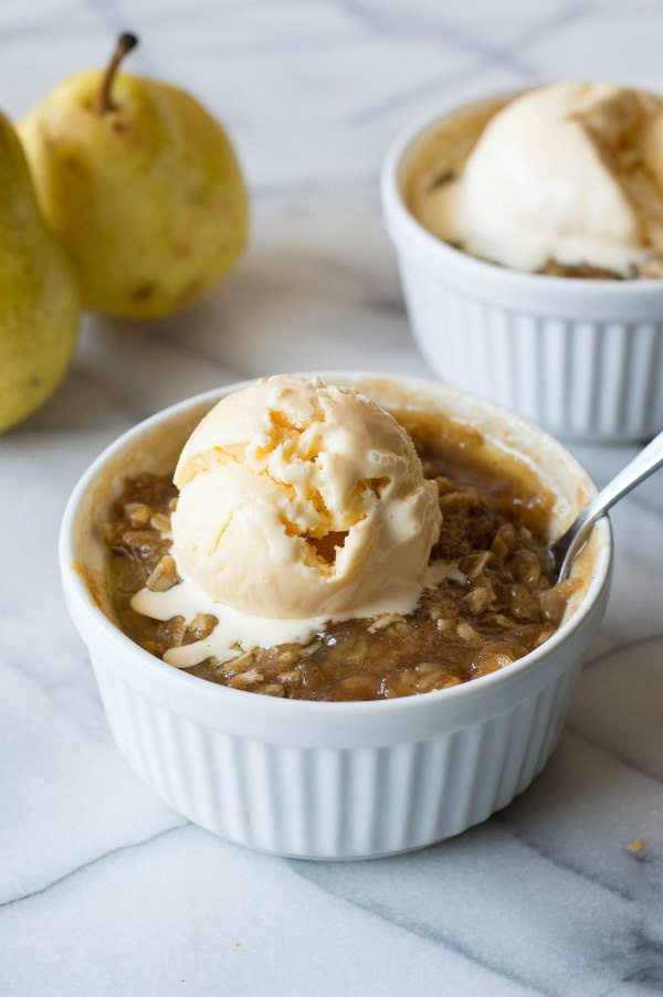 Easy Maple Ginger Pear Crisp in a ramekin with vanilla ice cream