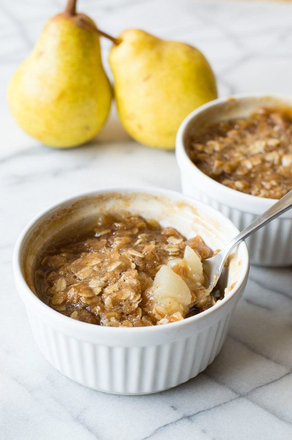 Easy Maple Ginger Pear Crisp in two ramekins with pears in background
