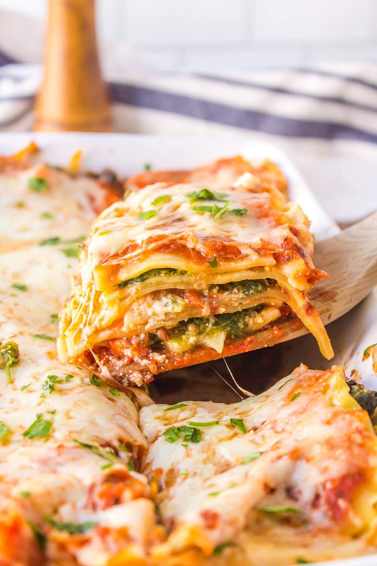 spatula taking slice of lasagna out of whole lasagna in pan