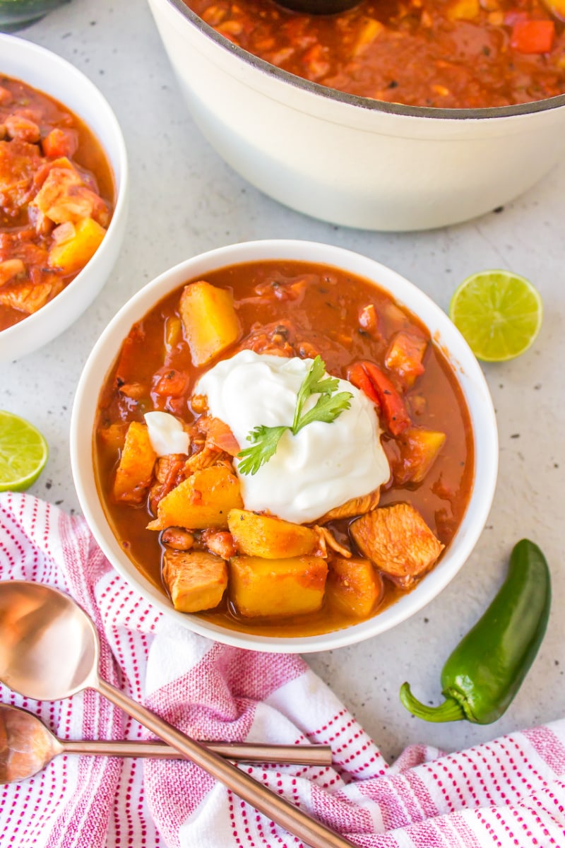 serving of acorn squash and chicken chili in bowl topped with sour cream