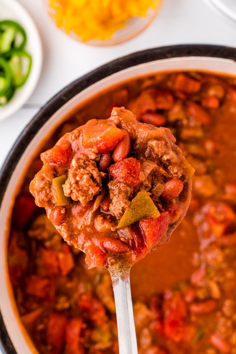 ladle pulling out scoop of chili from pot