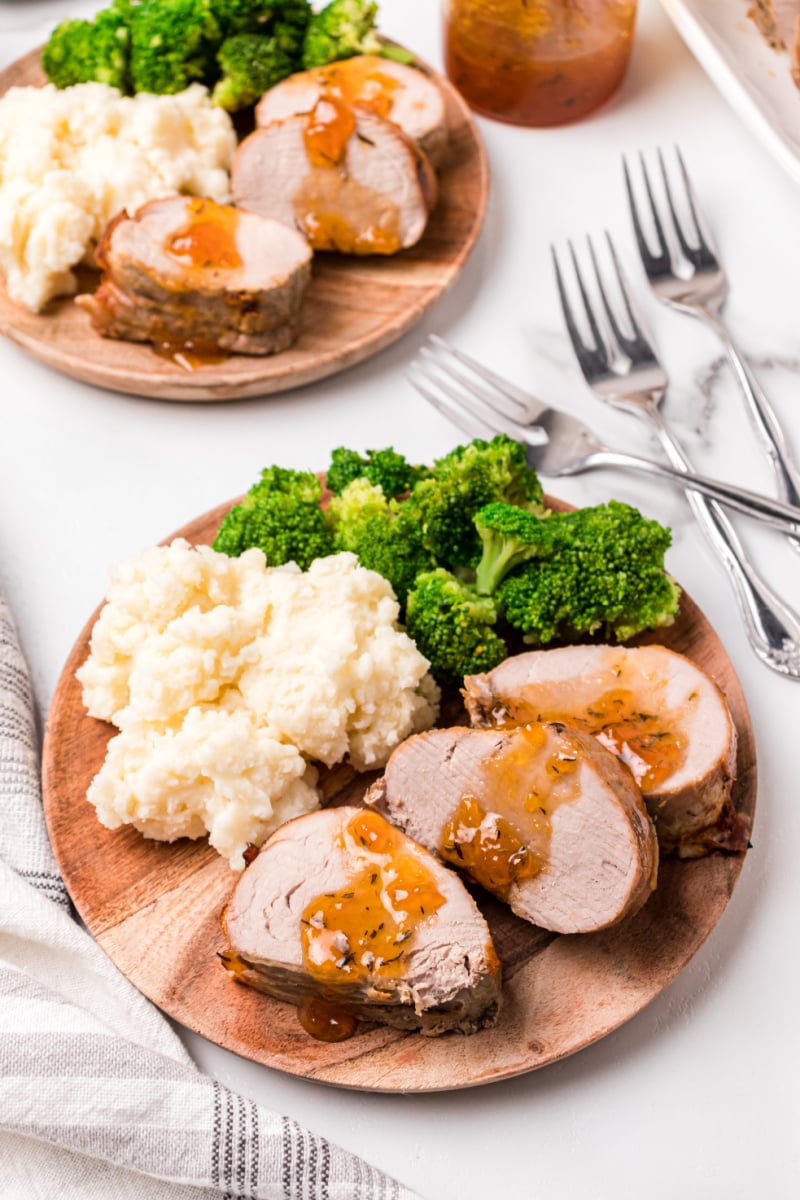 sliced apricot pork roast with potato and broccoli on a plate