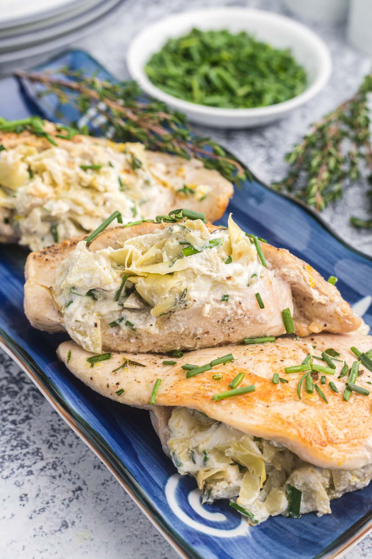 Artichoke and goat cheese stuffed chicken on platter