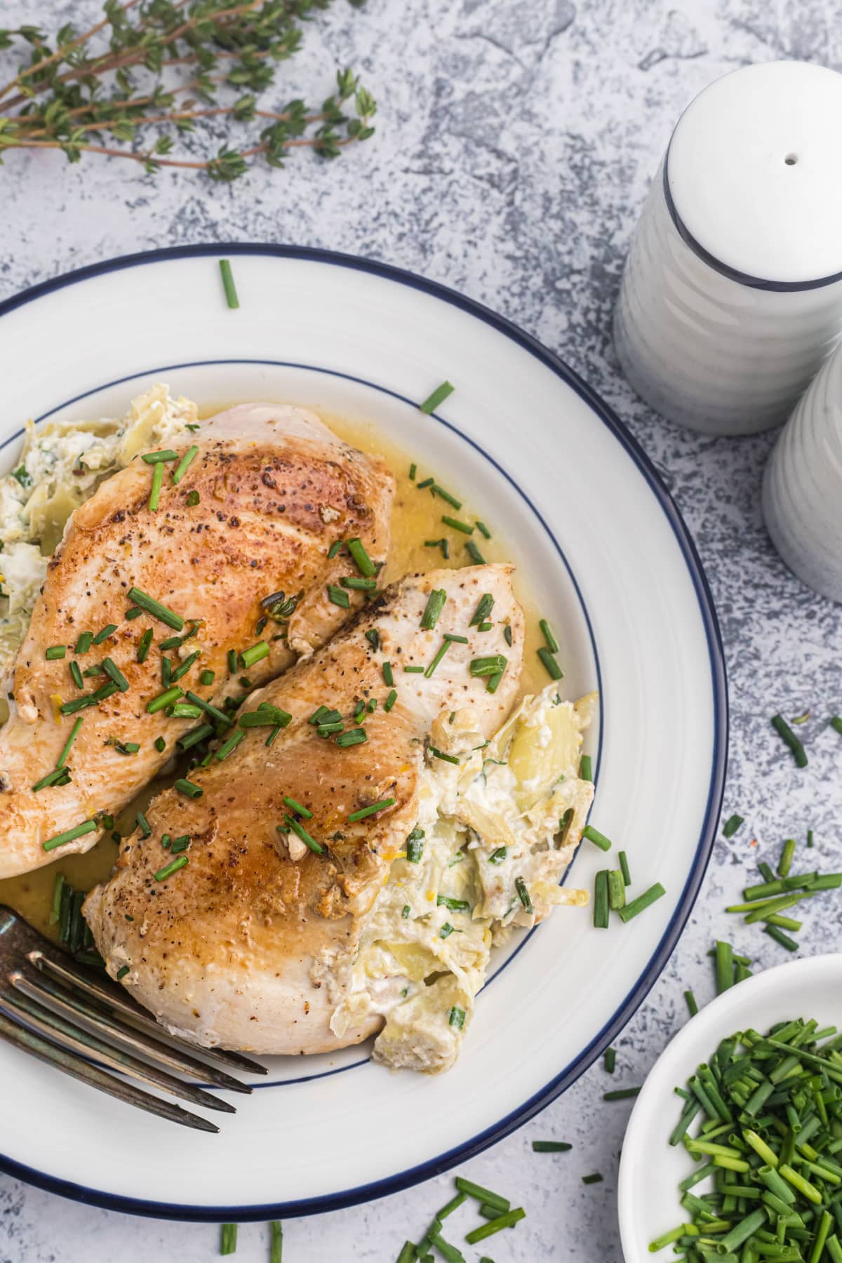 overhead shot of two chicken breasts stuffed with artichoke and goat cheese