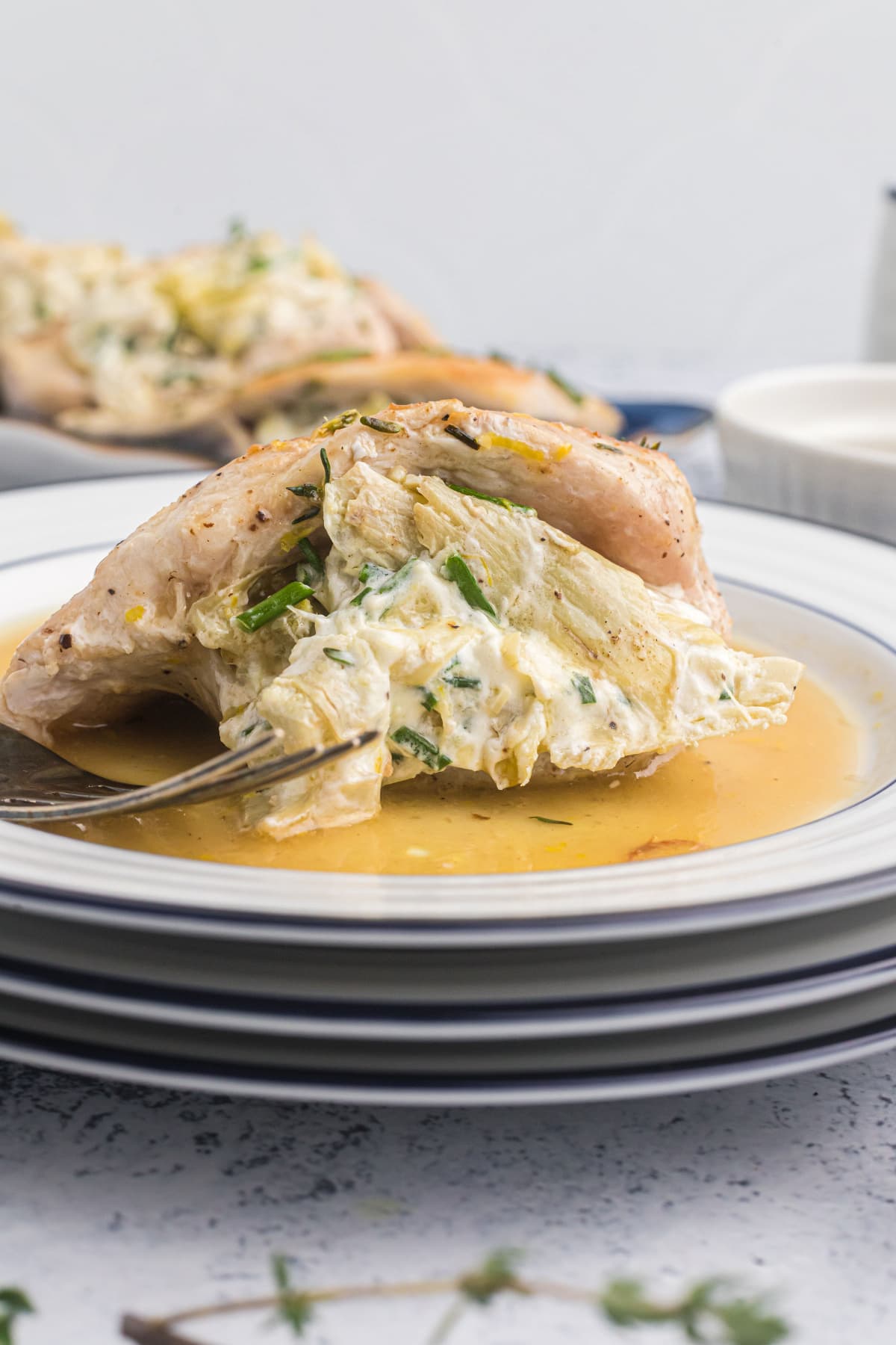 artichoke and goat cheese stuffed chicken on plate with fork