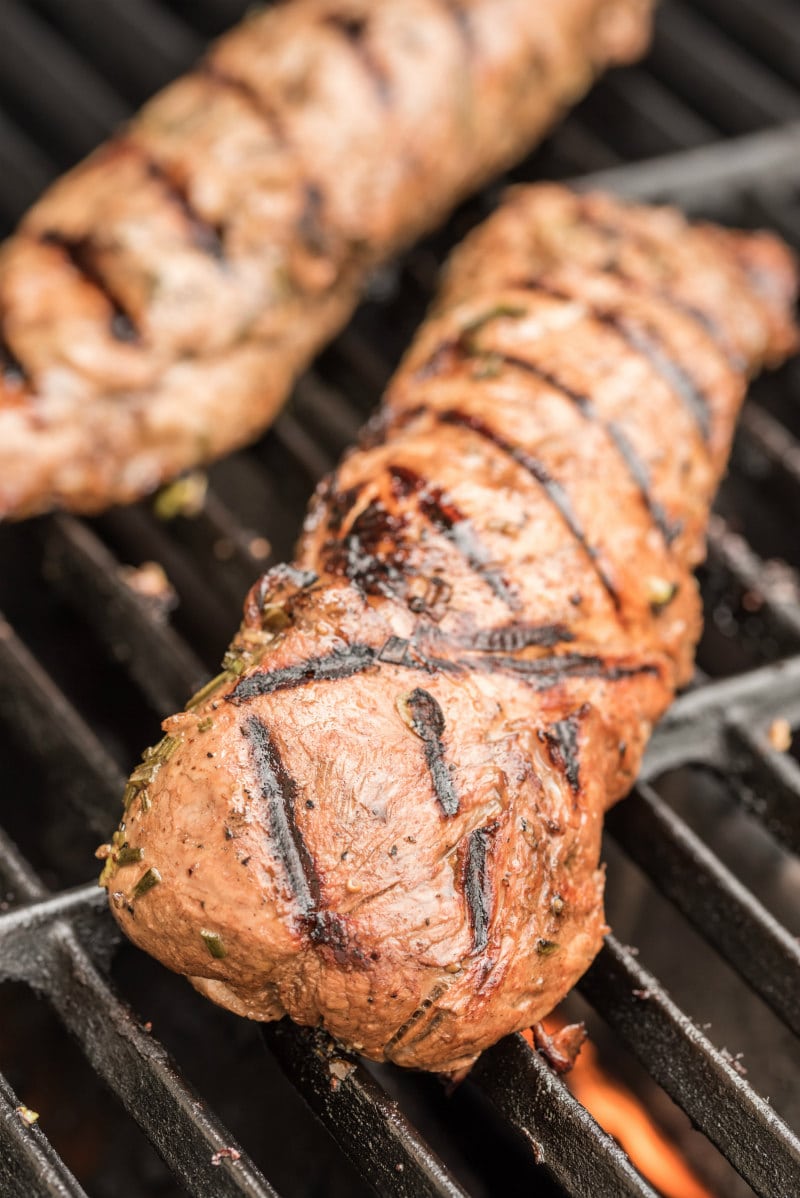 two pork tenderloins grilling on the grill