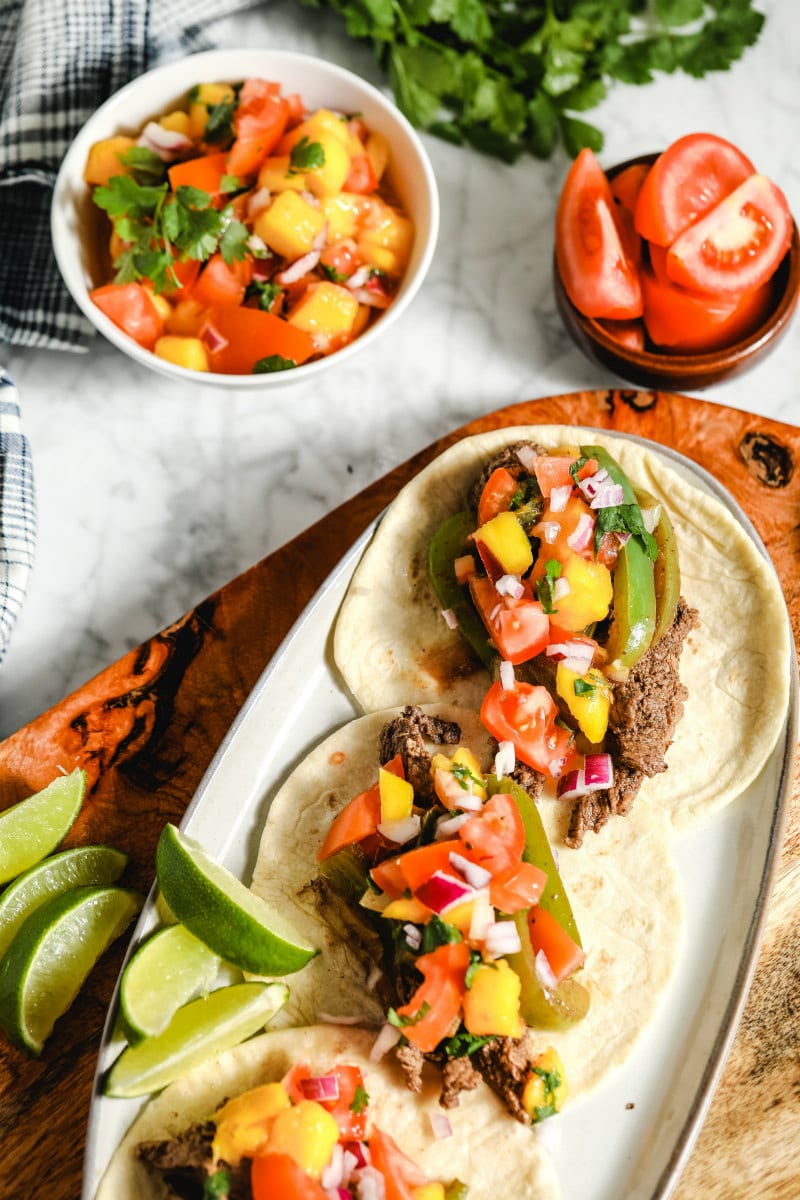 beef fajitas in flour tortillas on a serving platter