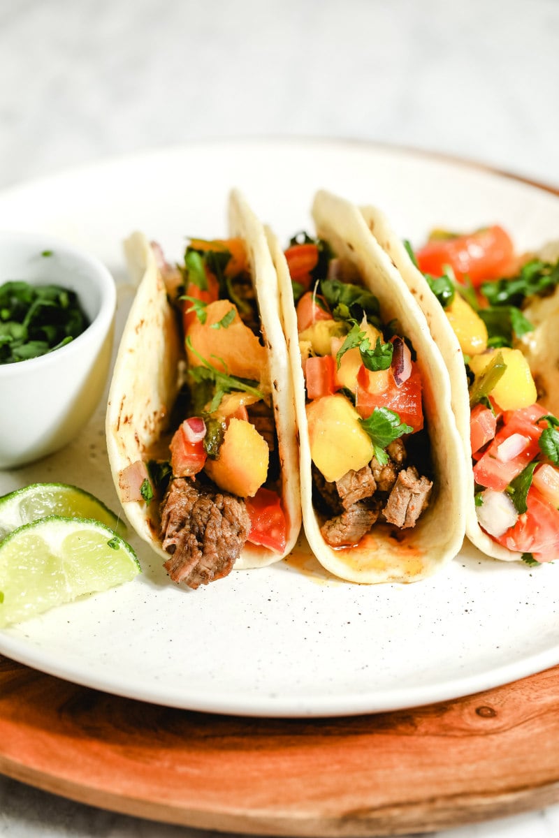 beef fajitas in flour tortillas on a serving plate